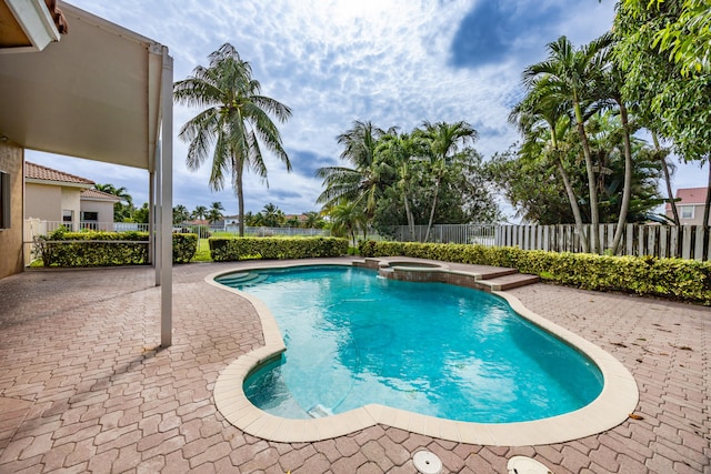 view of pool with a patio area, a fenced backyard, and a pool with connected hot tub