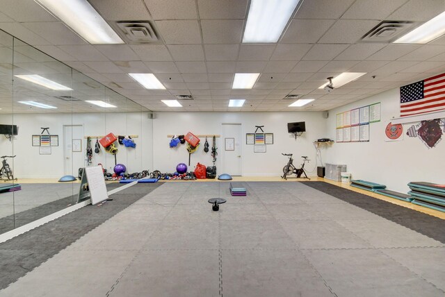 workout area with a paneled ceiling, baseboards, and visible vents