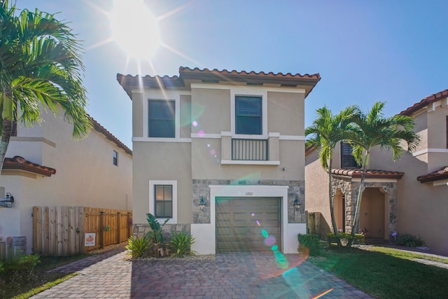 mediterranean / spanish house featuring a garage and a balcony