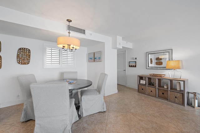 tiled dining space featuring an inviting chandelier