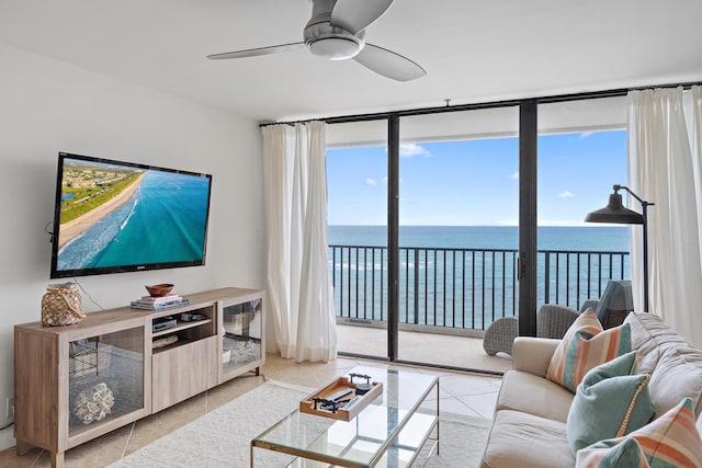 tiled living room with ceiling fan and a wall of windows