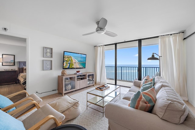 living room featuring ceiling fan and expansive windows