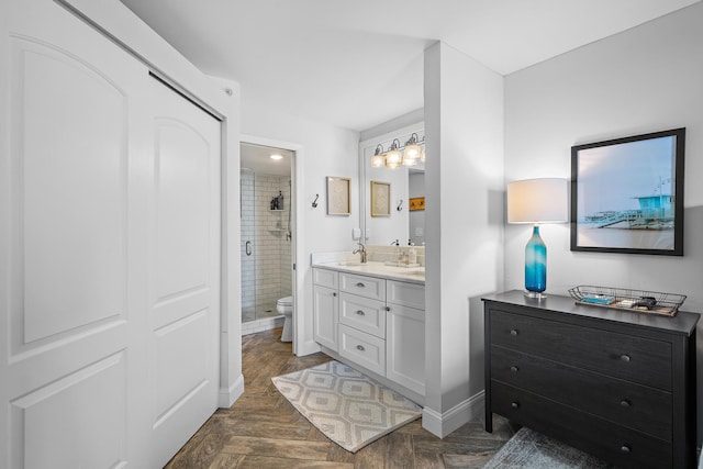 bathroom with toilet, vanity, a shower with door, and parquet flooring