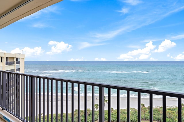 balcony featuring a water view and a view of the beach