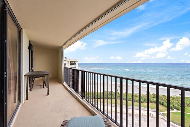 balcony featuring a water view and a beach view