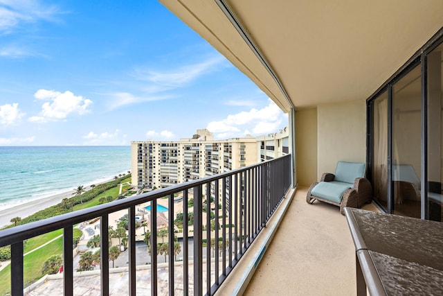 balcony featuring a view of the beach and a water view