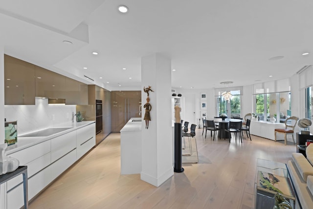 kitchen featuring black electric stovetop, decorative backsplash, gray cabinets, and light hardwood / wood-style flooring