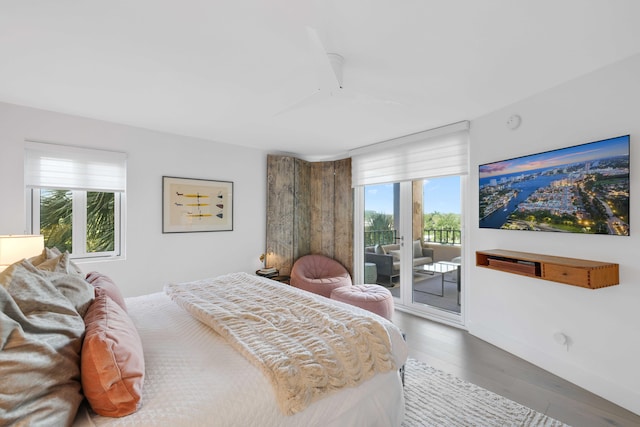 bedroom with hardwood / wood-style floors, access to exterior, and multiple windows