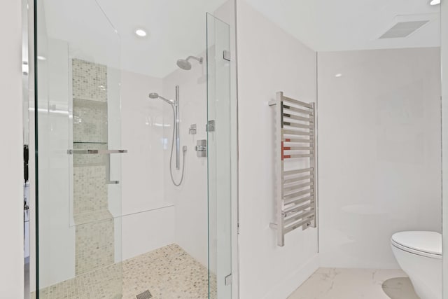 bathroom with radiator, a shower with shower door, and toilet