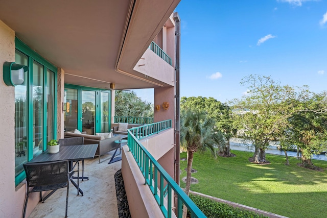 balcony with outdoor lounge area, a water view, and a patio