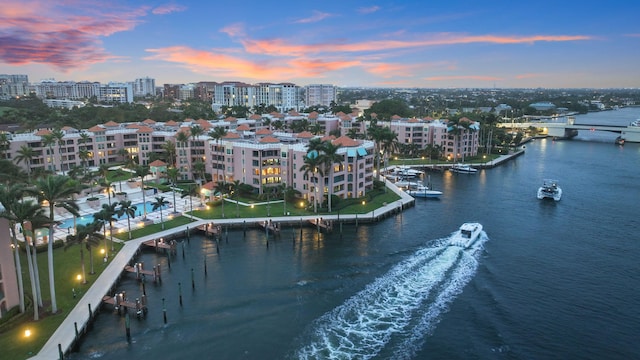 aerial view at dusk featuring a water view