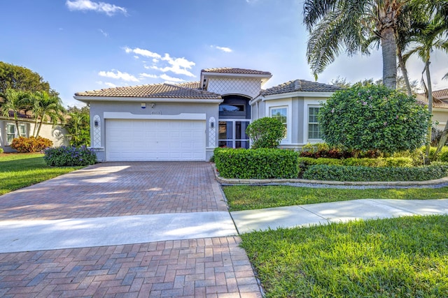 mediterranean / spanish home with a front yard and a garage