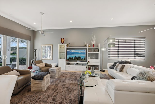 living room with ceiling fan and crown molding