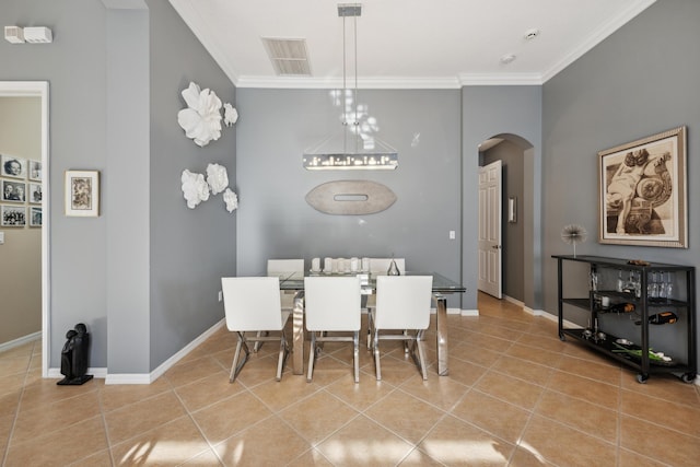 dining area with light tile patterned flooring and crown molding