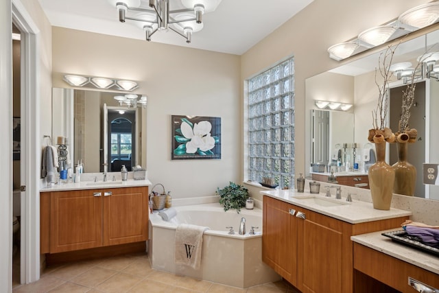 bathroom with a bathtub, tile patterned floors, vanity, and a notable chandelier