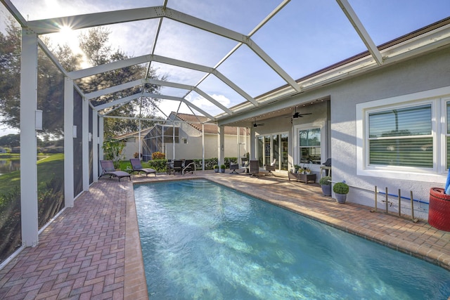 view of pool featuring ceiling fan, glass enclosure, and a patio area