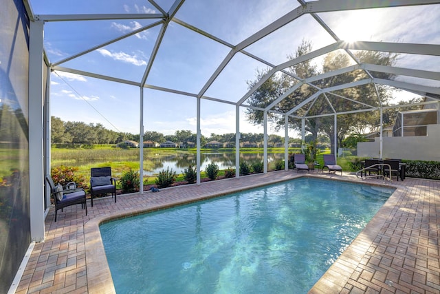 view of pool with a lanai, a water view, and a patio