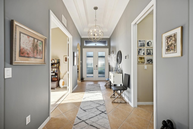 entrance foyer with light tile patterned floors, crown molding, french doors, and an inviting chandelier