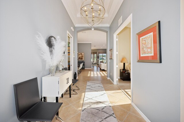 hallway featuring light tile patterned floors, a notable chandelier, and crown molding