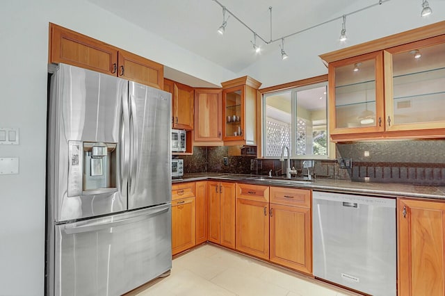 kitchen with rail lighting, sink, light tile patterned floors, appliances with stainless steel finishes, and tasteful backsplash