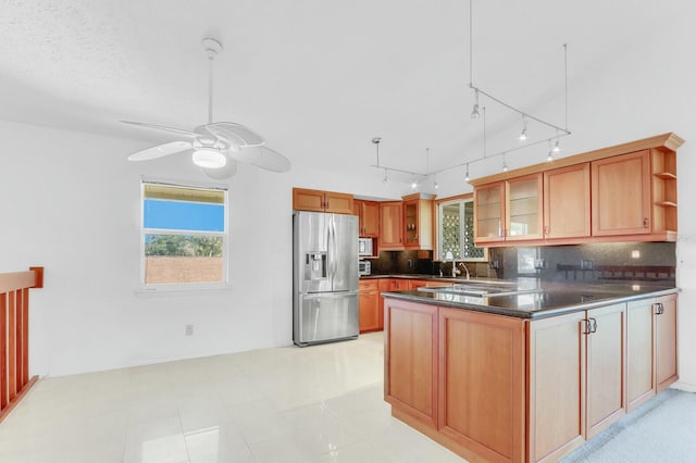 kitchen featuring plenty of natural light, stainless steel fridge, backsplash, and ceiling fan