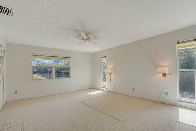 empty room featuring light colored carpet and ceiling fan