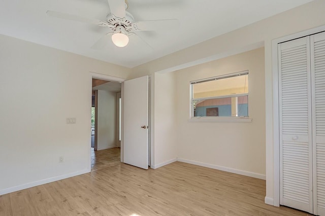 unfurnished bedroom featuring ceiling fan, a closet, and light wood-type flooring