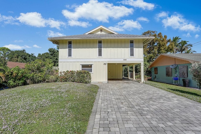 view of front of house with a front lawn and a carport