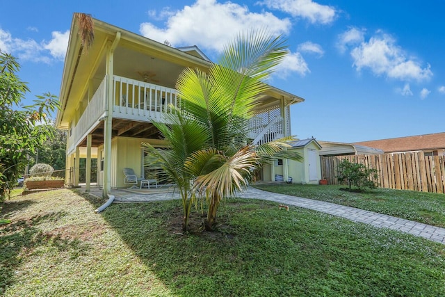 rear view of property featuring a yard, a patio, and ceiling fan