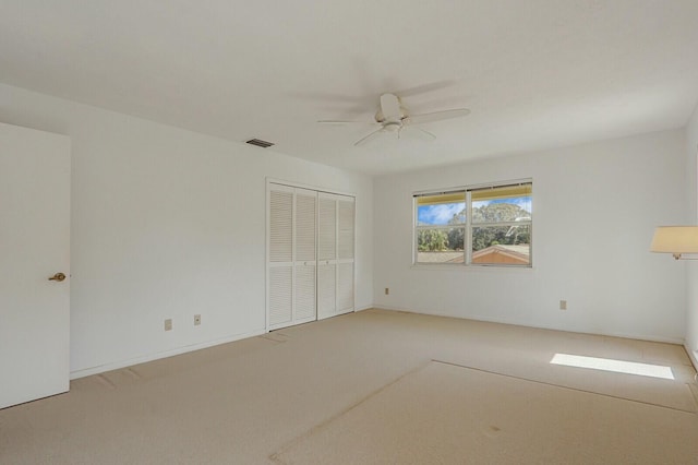 unfurnished bedroom with ceiling fan, carpet floors, and a closet