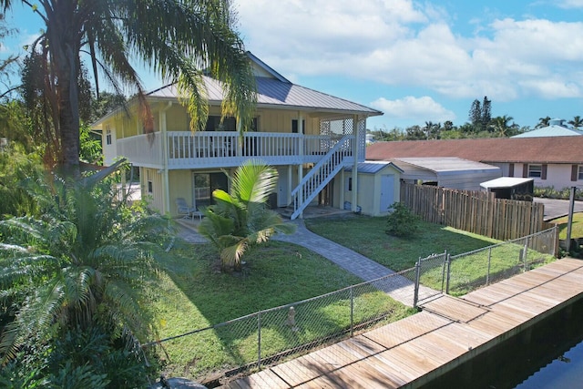 view of front of property featuring a front lawn and a storage shed