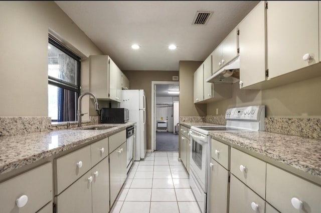 kitchen featuring white electric range oven, sink, white cabinets, black dishwasher, and light tile patterned flooring