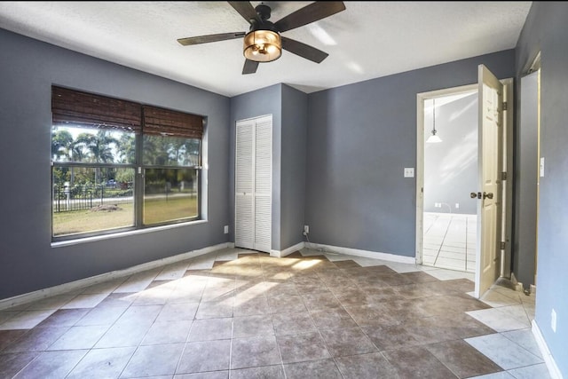 tiled spare room featuring ceiling fan and a textured ceiling