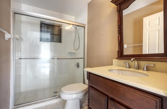 bathroom featuring tile patterned flooring, vanity, toilet, and an enclosed shower