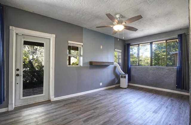 unfurnished room featuring a textured ceiling, ceiling fan, and dark wood-type flooring