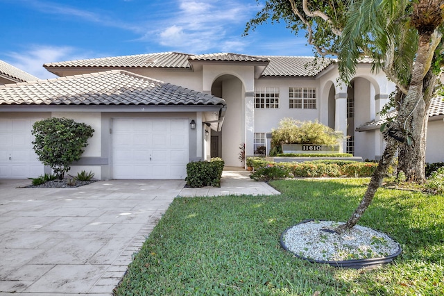 mediterranean / spanish-style home featuring a garage and a front lawn