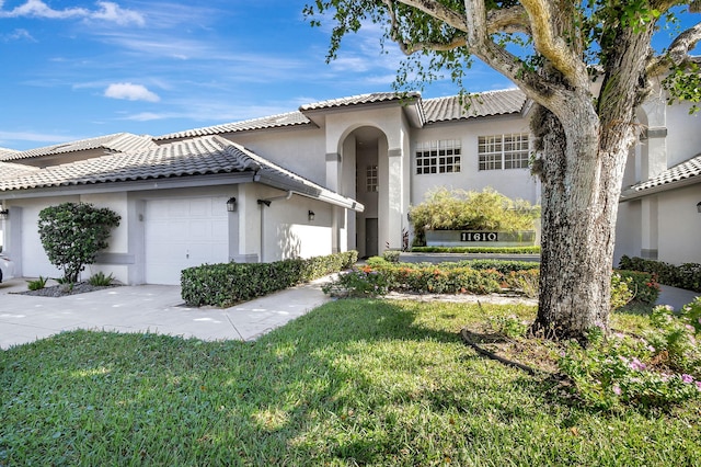 mediterranean / spanish-style house featuring a front lawn and a garage