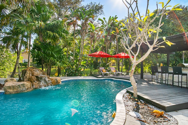 view of swimming pool featuring pool water feature and a wooden deck