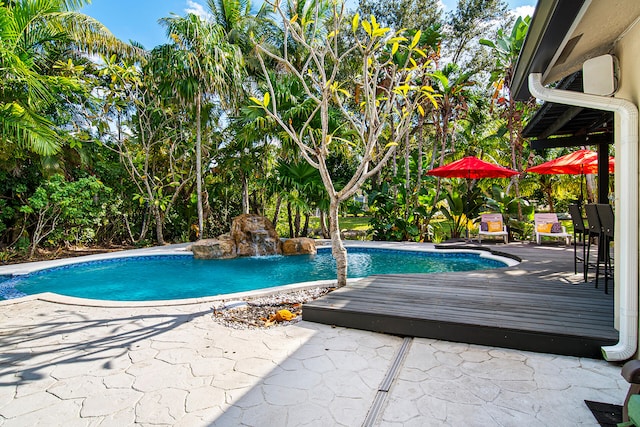 view of swimming pool with pool water feature and a wooden deck