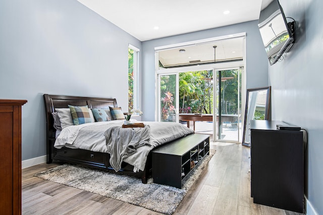 bedroom with access to exterior and light hardwood / wood-style flooring