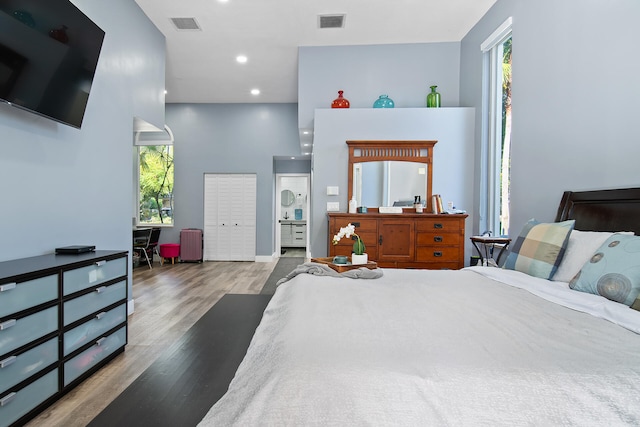 bedroom featuring radiator, dark hardwood / wood-style floors, a closet, and a high ceiling