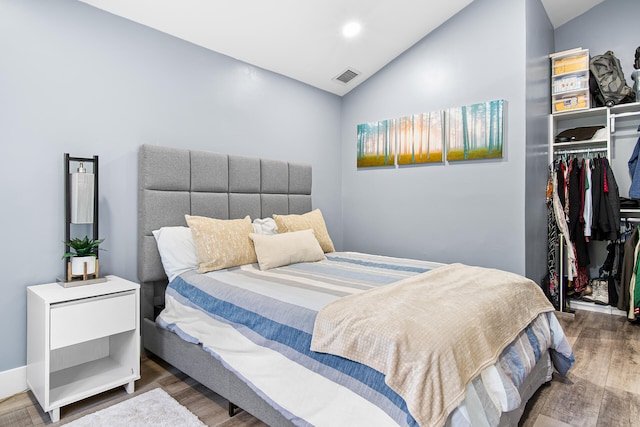 bedroom with wood-type flooring, a closet, and lofted ceiling