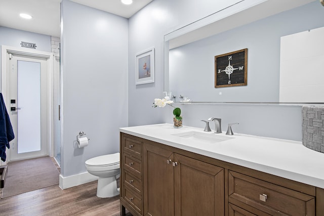 bathroom with hardwood / wood-style floors, vanity, and toilet