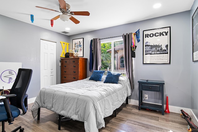 bedroom featuring ceiling fan, wood-type flooring, and a closet