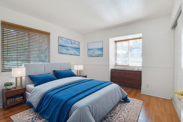 bedroom featuring hardwood / wood-style flooring and a textured ceiling