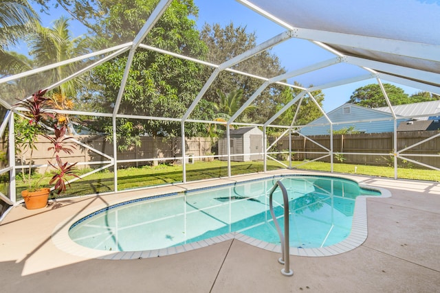 view of swimming pool with a lawn, glass enclosure, a storage shed, and a patio