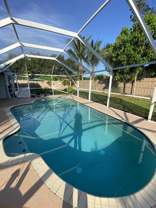 view of swimming pool featuring a lanai and a patio