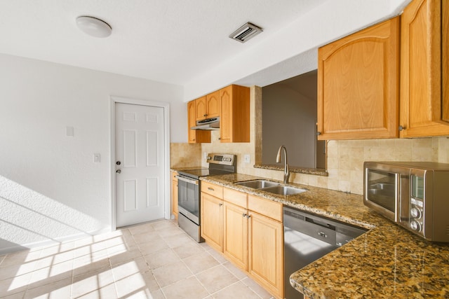 kitchen featuring light tile patterned floors, decorative backsplash, appliances with stainless steel finishes, dark stone countertops, and sink