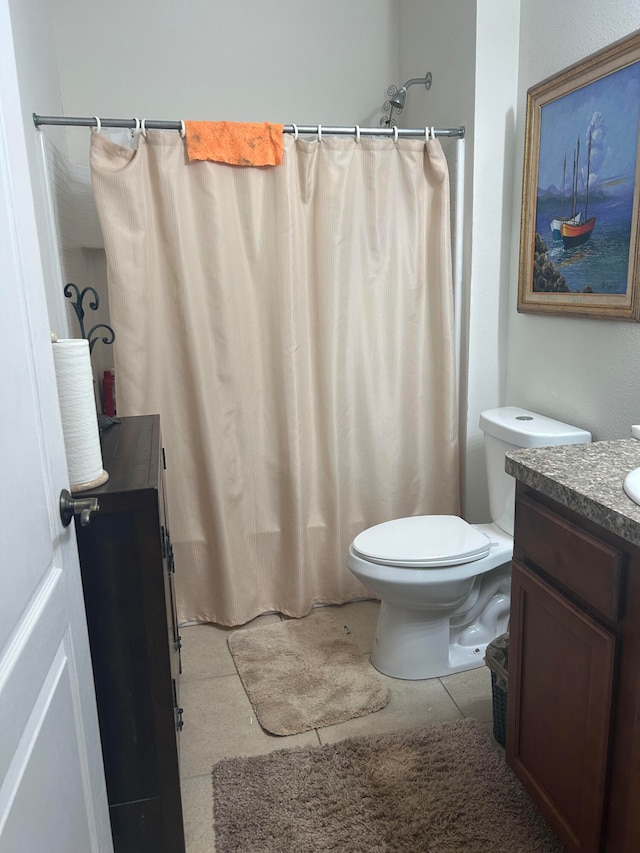 bathroom featuring tile patterned flooring, vanity, toilet, and curtained shower