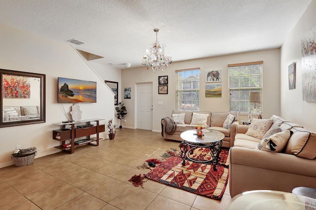 living room with a textured ceiling, an inviting chandelier, and light tile patterned flooring